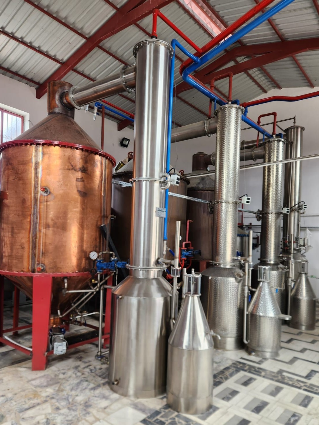 Traditional rose oil steam-distillation system with copper and stainless-steel units.