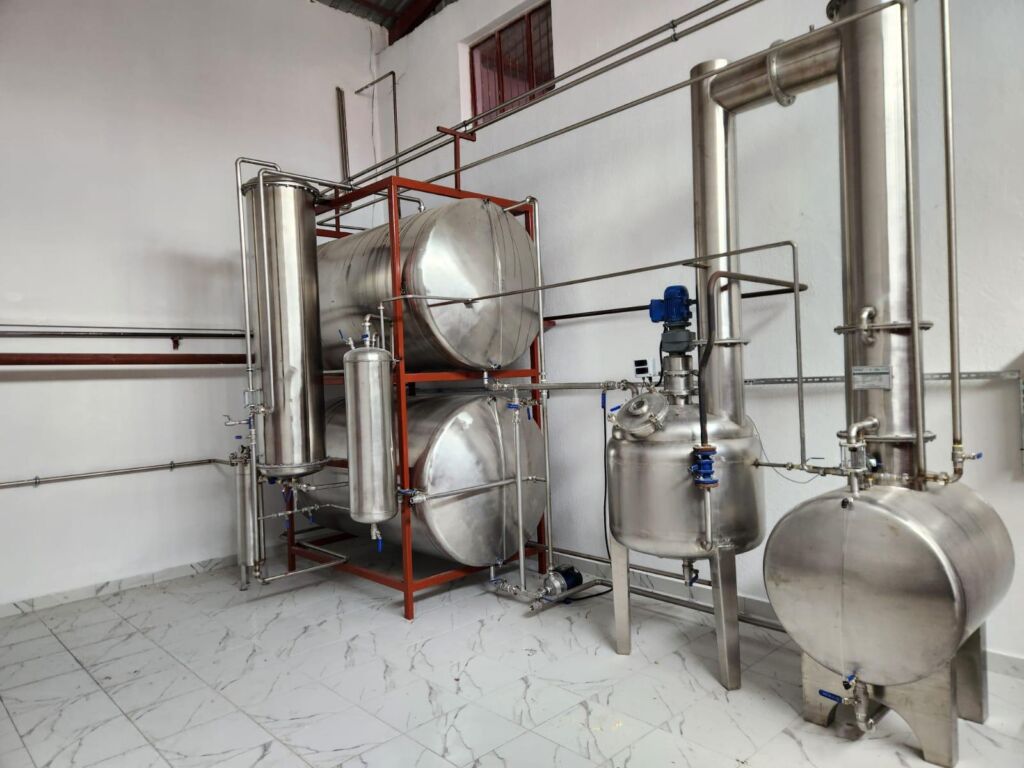 Stainless steel distillation system with interconnected storage tanks and modern pipelines.