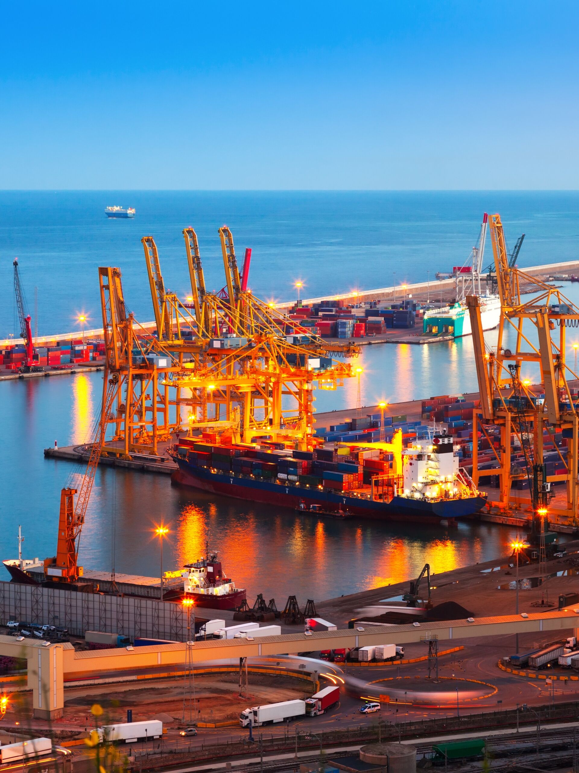 Cargo port with cranes loading and unloading containers for international shipping.